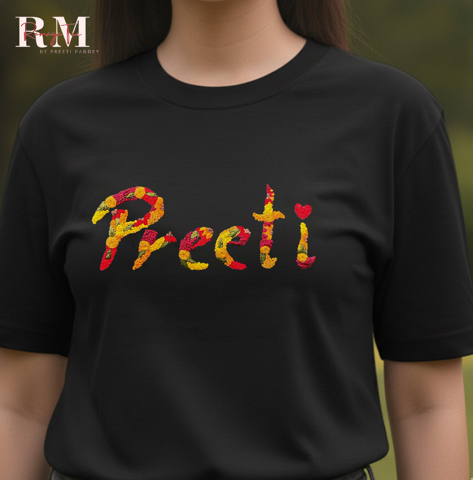 Black t-shirt with colorful name 'Preeti' on a blurred green background