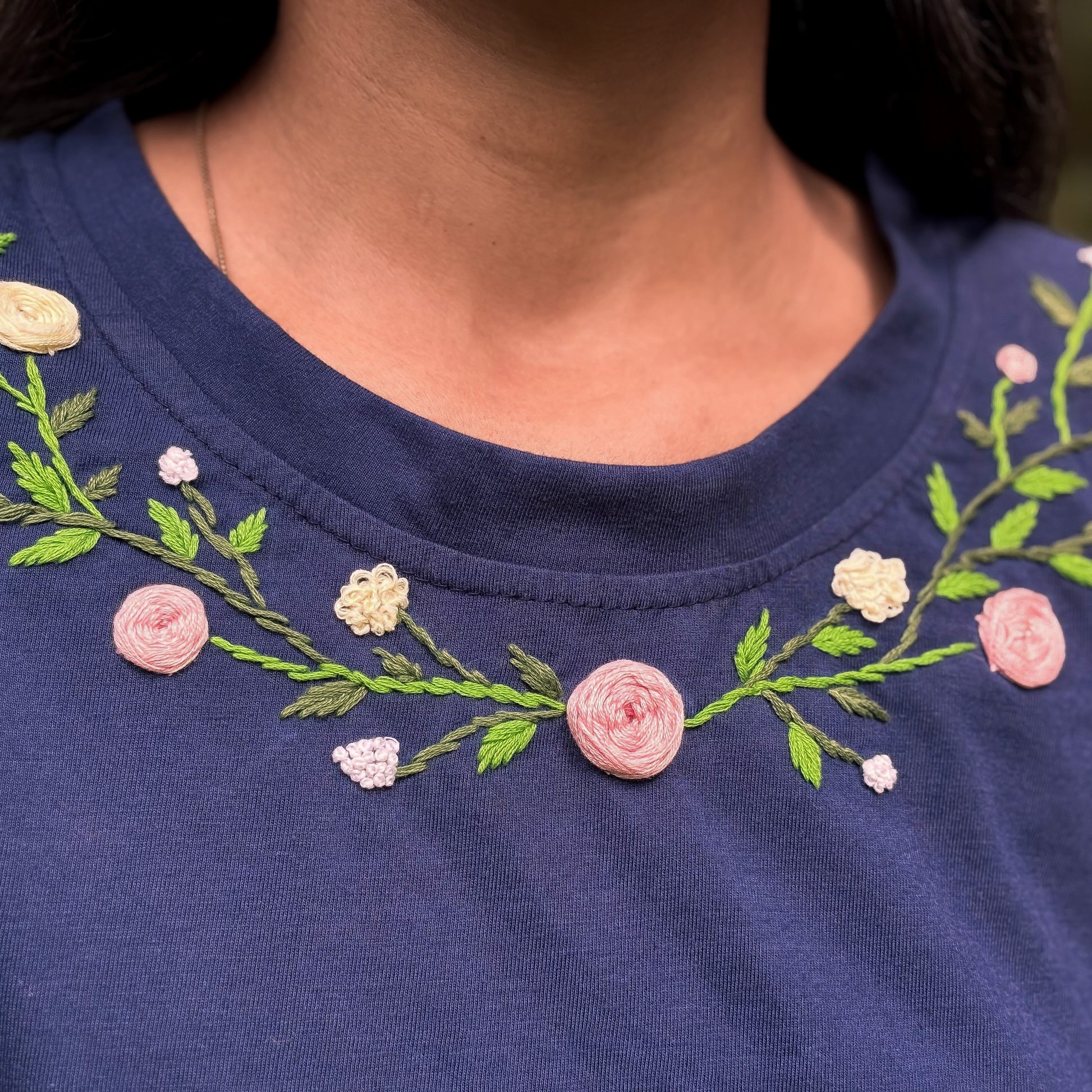 Ramayatee handmade floral embroidery cotton t-shirt for women
Navy blue shirt with floral embroidery on a person's neck