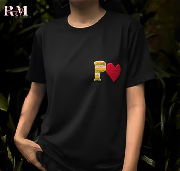 Person wearing a black t-shirt with a colorful design on a dark background