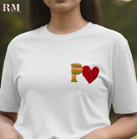 White t-shirt with colorful 'P' and red heart design on a blurred background Personalized Couple Gift T-shirt with Custom Initials and Hand Embroidered Heart (UNISEX White T-shirt)